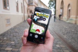 Handy auf Straße mit geöffneter Pokémon-Go App